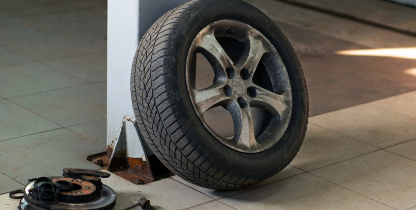 Car tire leaning against a wall